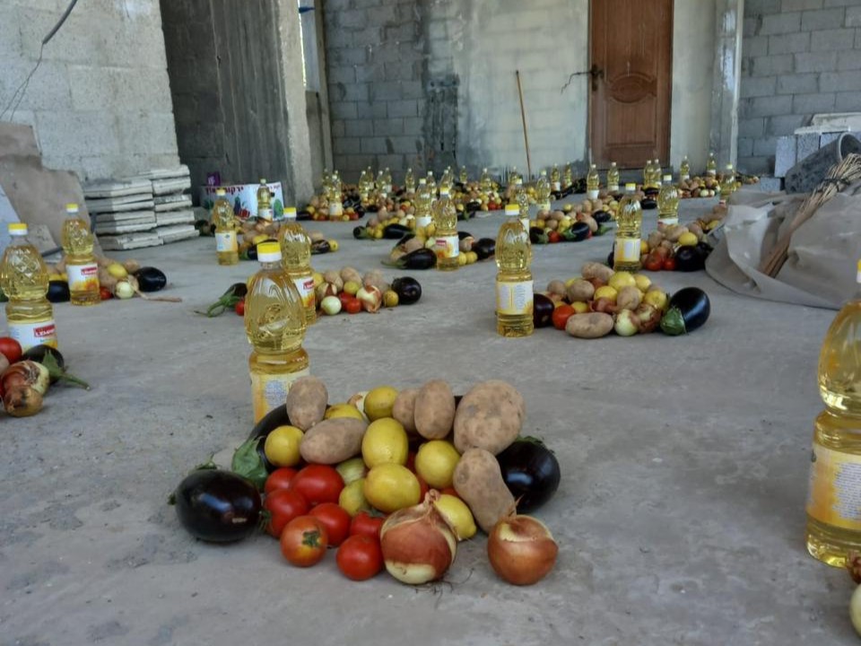 ISNAD food aid packages including fresh vegetables and oil being prepared.
